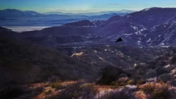 Illustration depicting a mysterious black triangular aerial object reportedly spotted over US military bases at high speed.